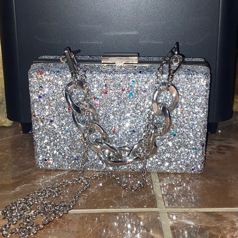 A silver crossbody purse. It was bought from Macy’s, but doesn’t say the brand.